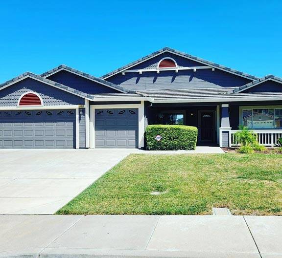 House with a three car garage and a fresh gray paint job with red accents in Blackhawk, California